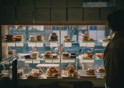 Warm bakery setting showcasing assorted pastries on display shelves.